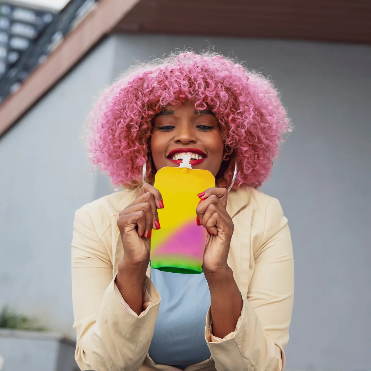 Eine Frau trinkt aus einer bunten Squeeze-Flasche