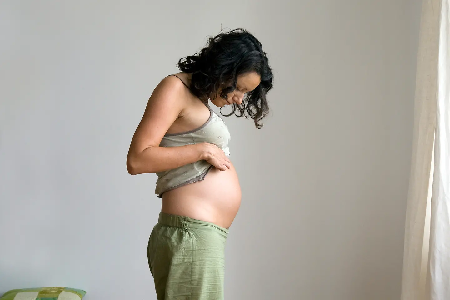 Junge Schwangere schaut auf ihren Bauch