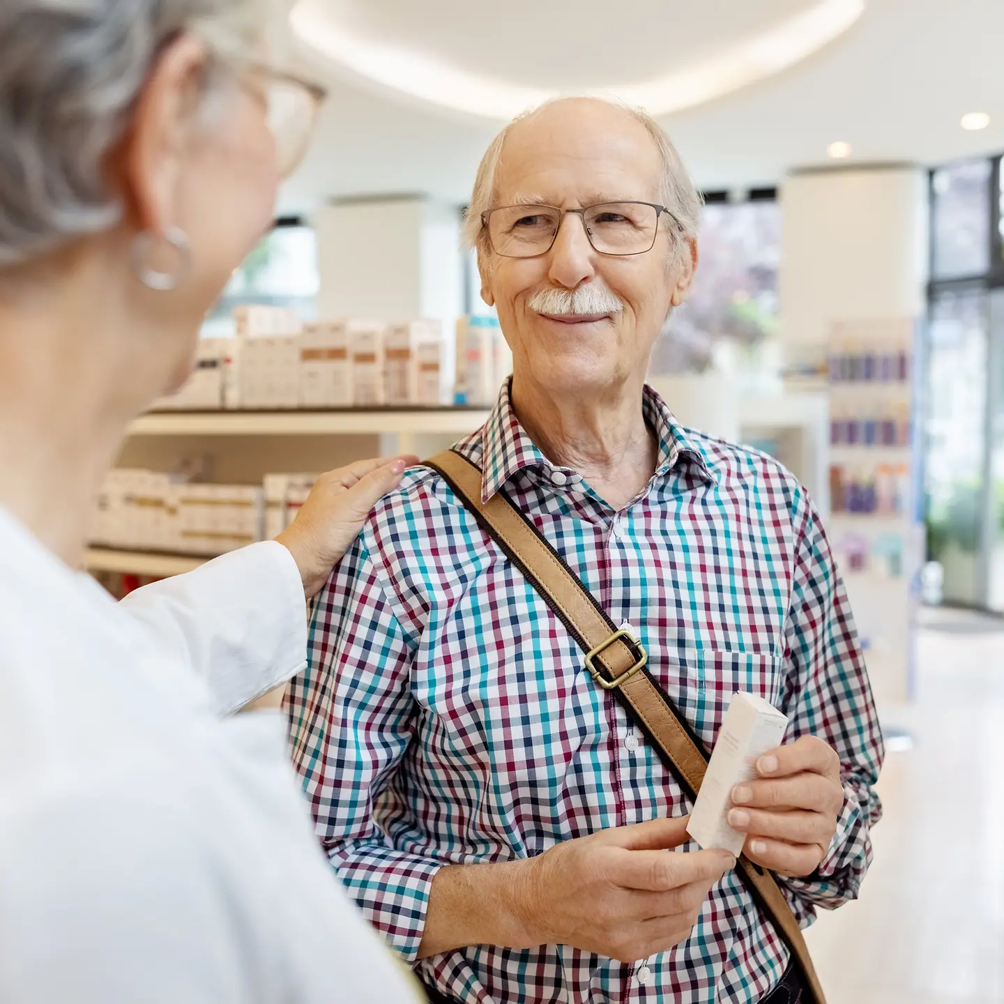 Älterer Mann mit Arzneimitteln in der Apotheke