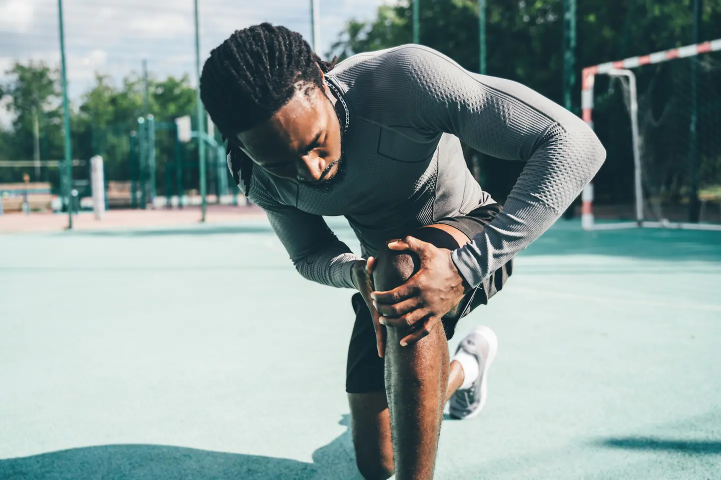 Ein sportlich aktiver Mann mit Knieschmerzen während des Trainings