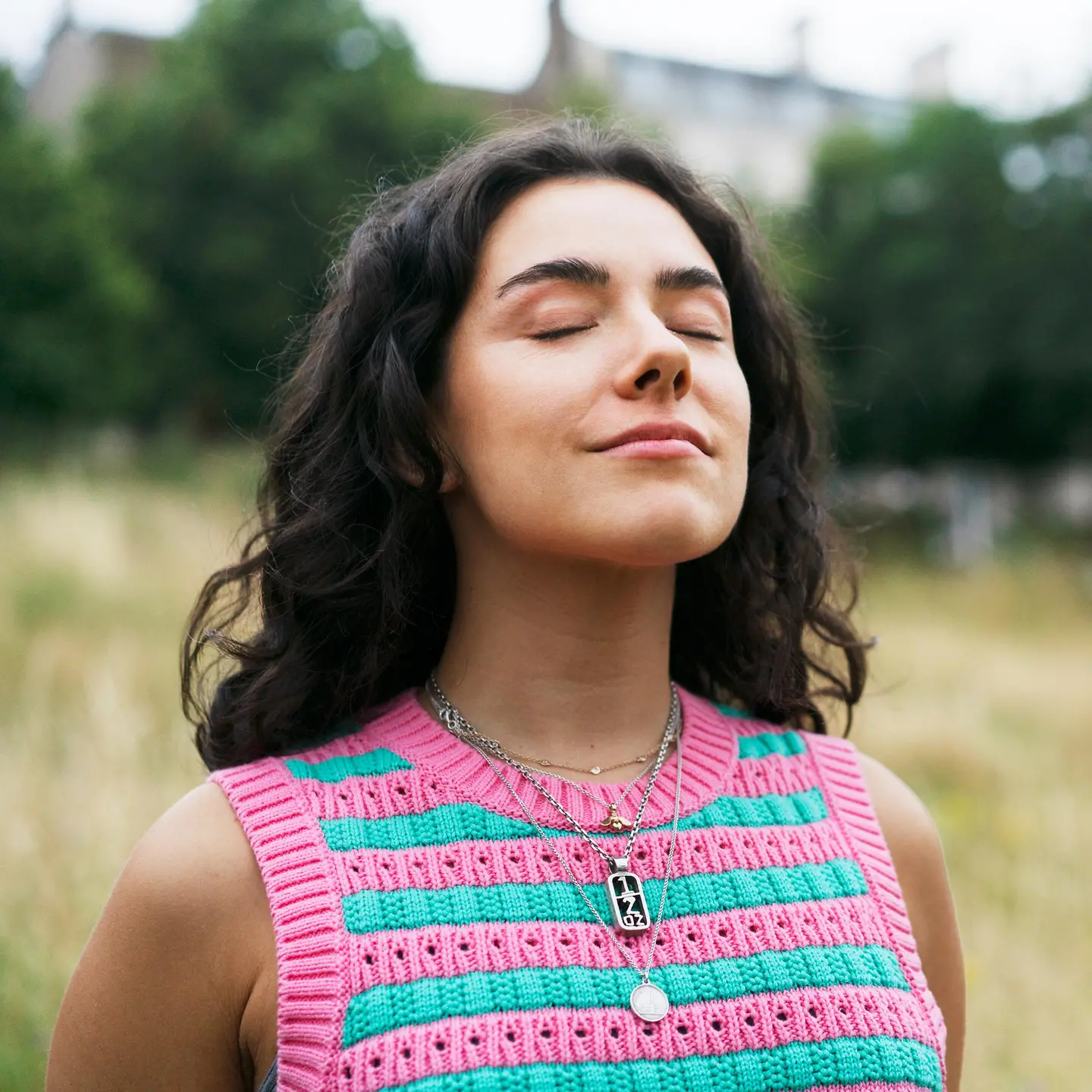 Eine Frau steht auf einem Feld und atmet tief durch