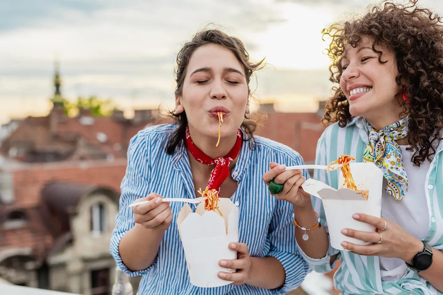 Zwei Frauen essen draußen Streetfood
