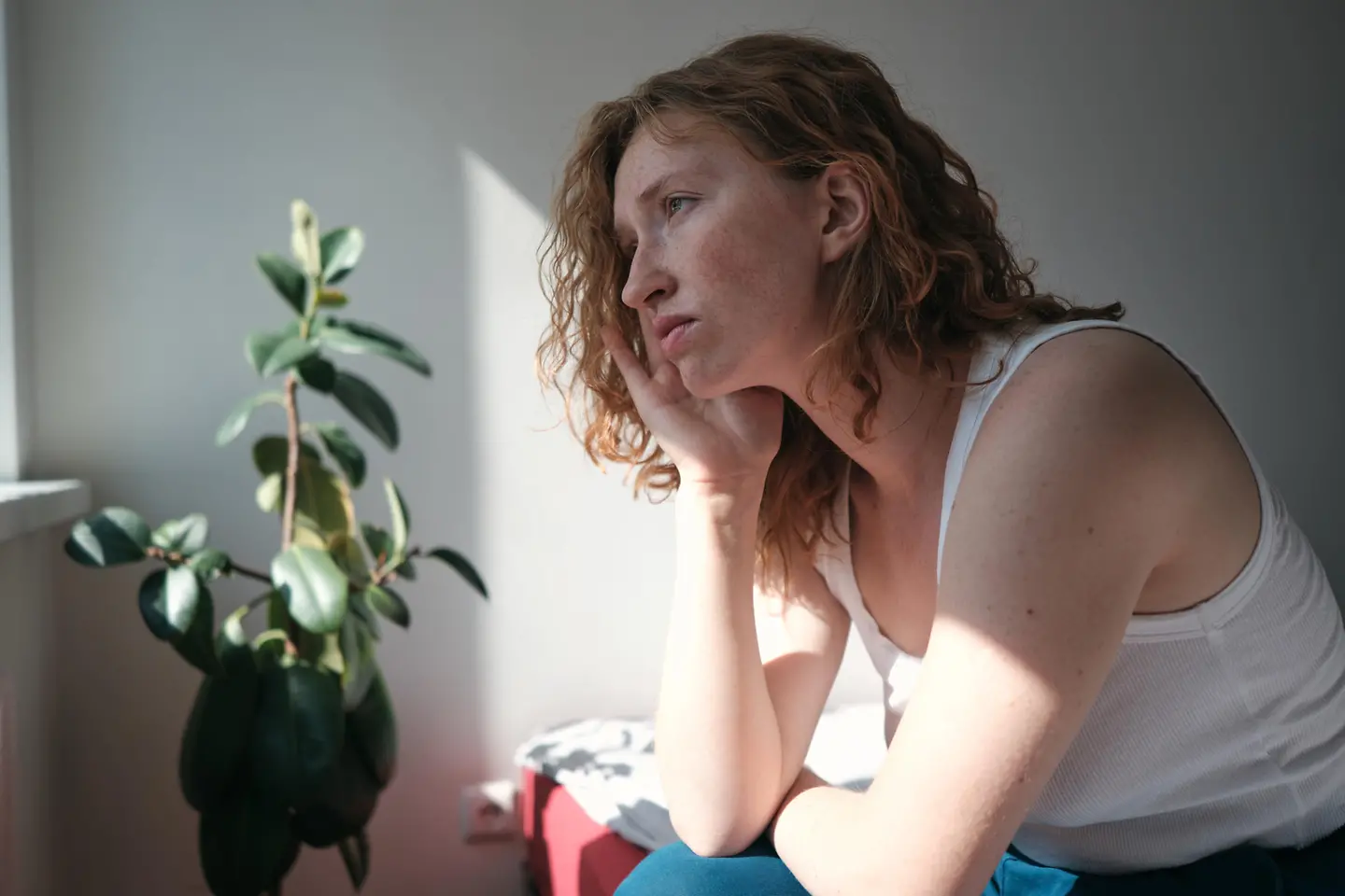 Eine traurige Frau sitzt auf ihrem Brett und hält sich den Kopf