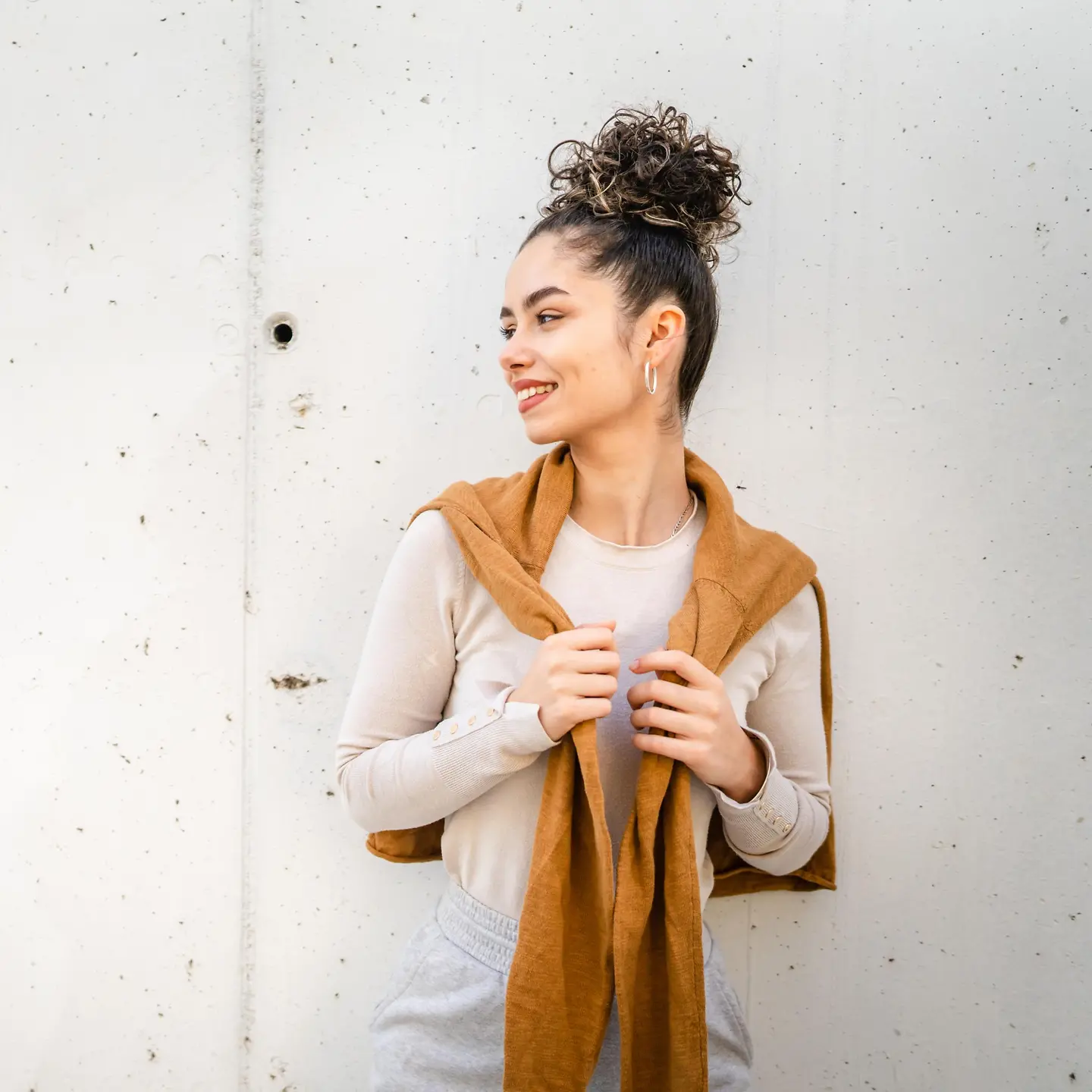 Eine junge Frau steht vor einer Betonwand