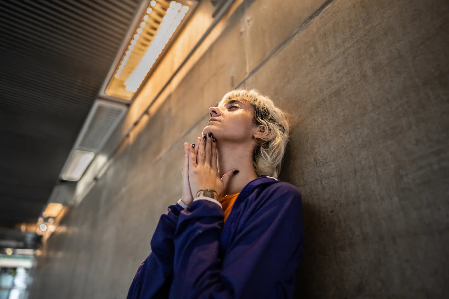 Besorgte junge Frau betet an einer U-Bahn-Station