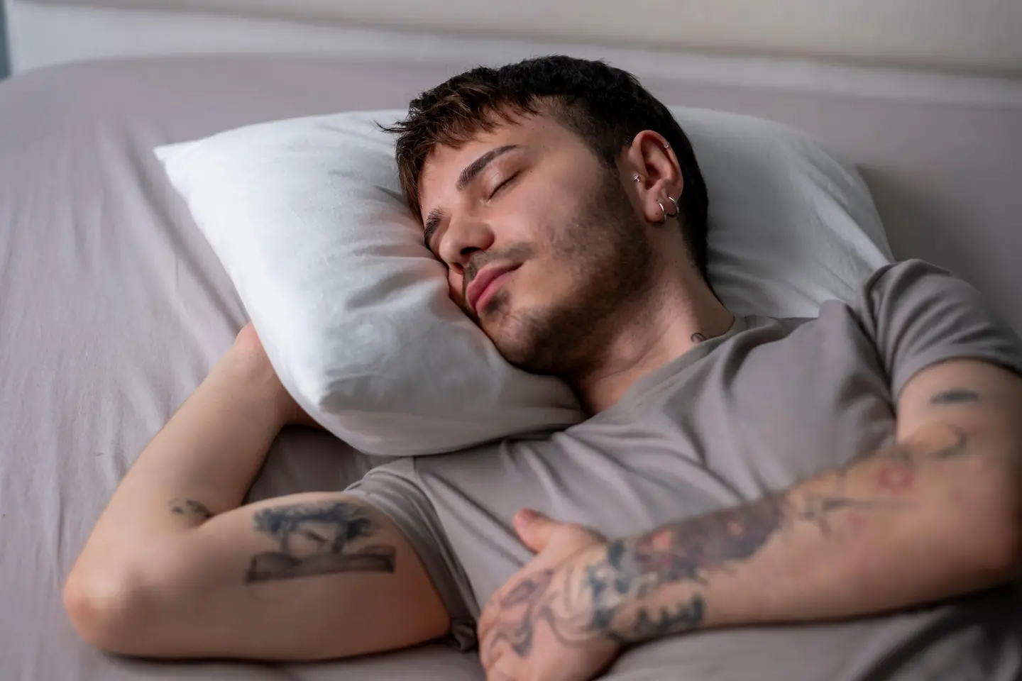 Junger Mann schläft tief in seinem Bett