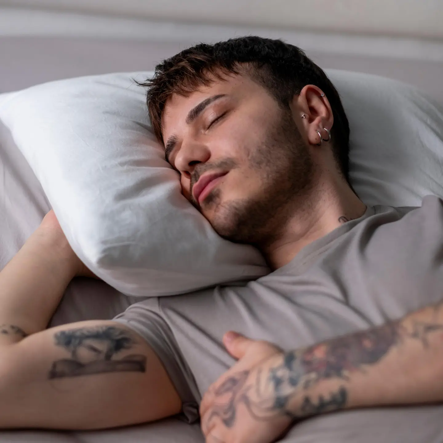 Junger Mann schläft tief in seinem Bett