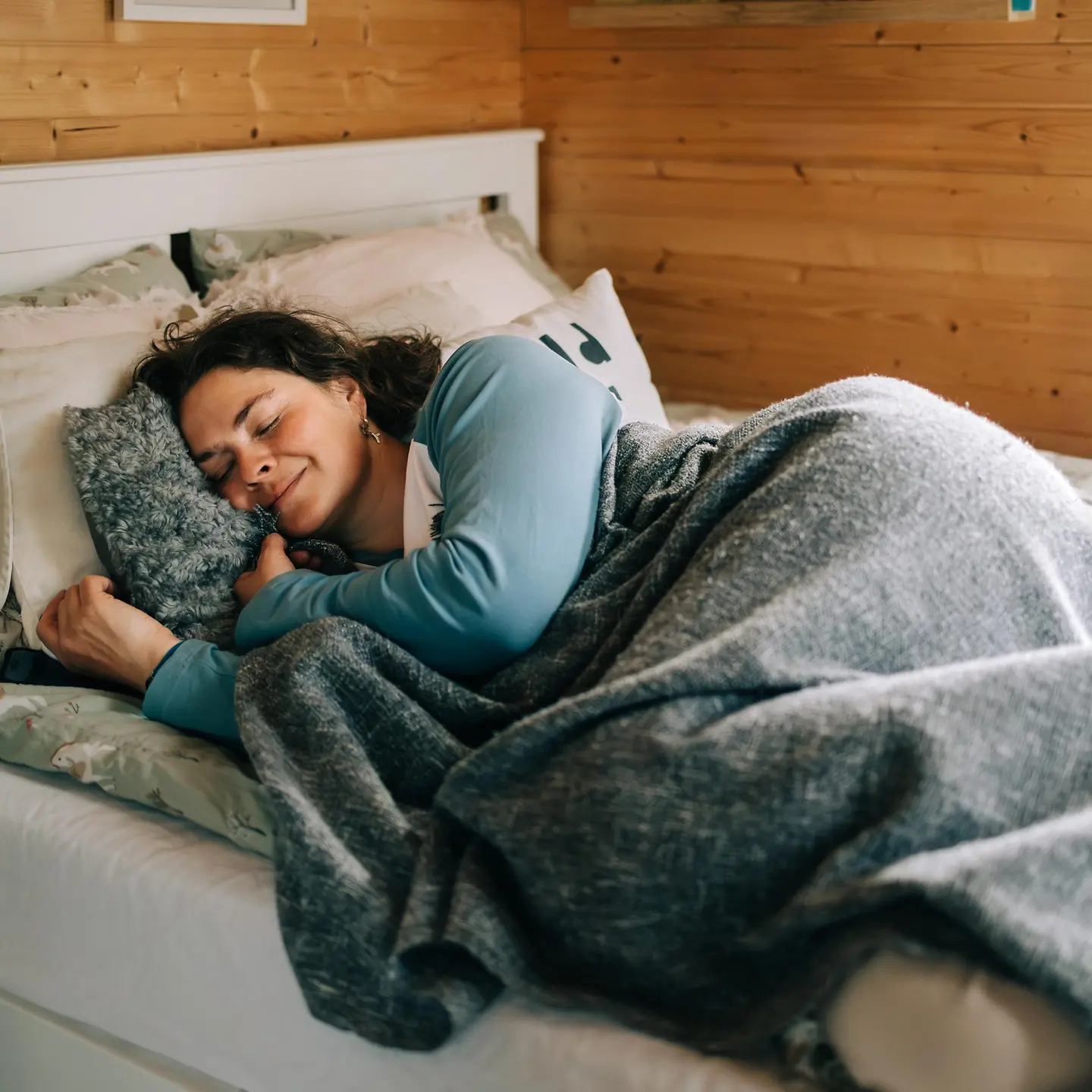 Frau schläft friedlich in ihrem Bett