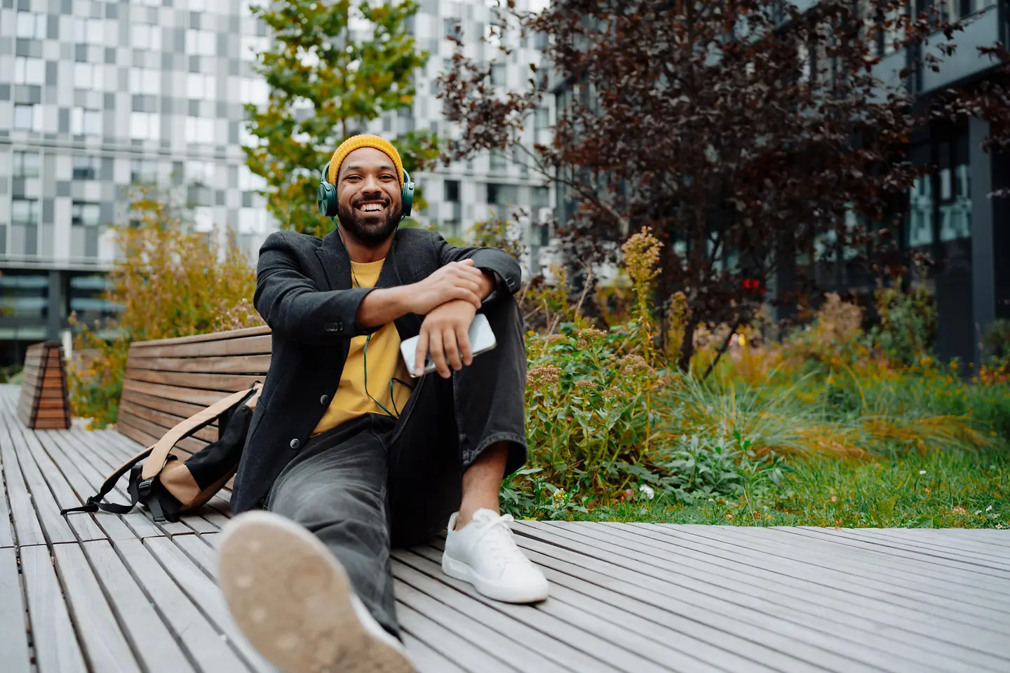 Junger Mann entspannt mit Kopfhörer auf eine Terrasse