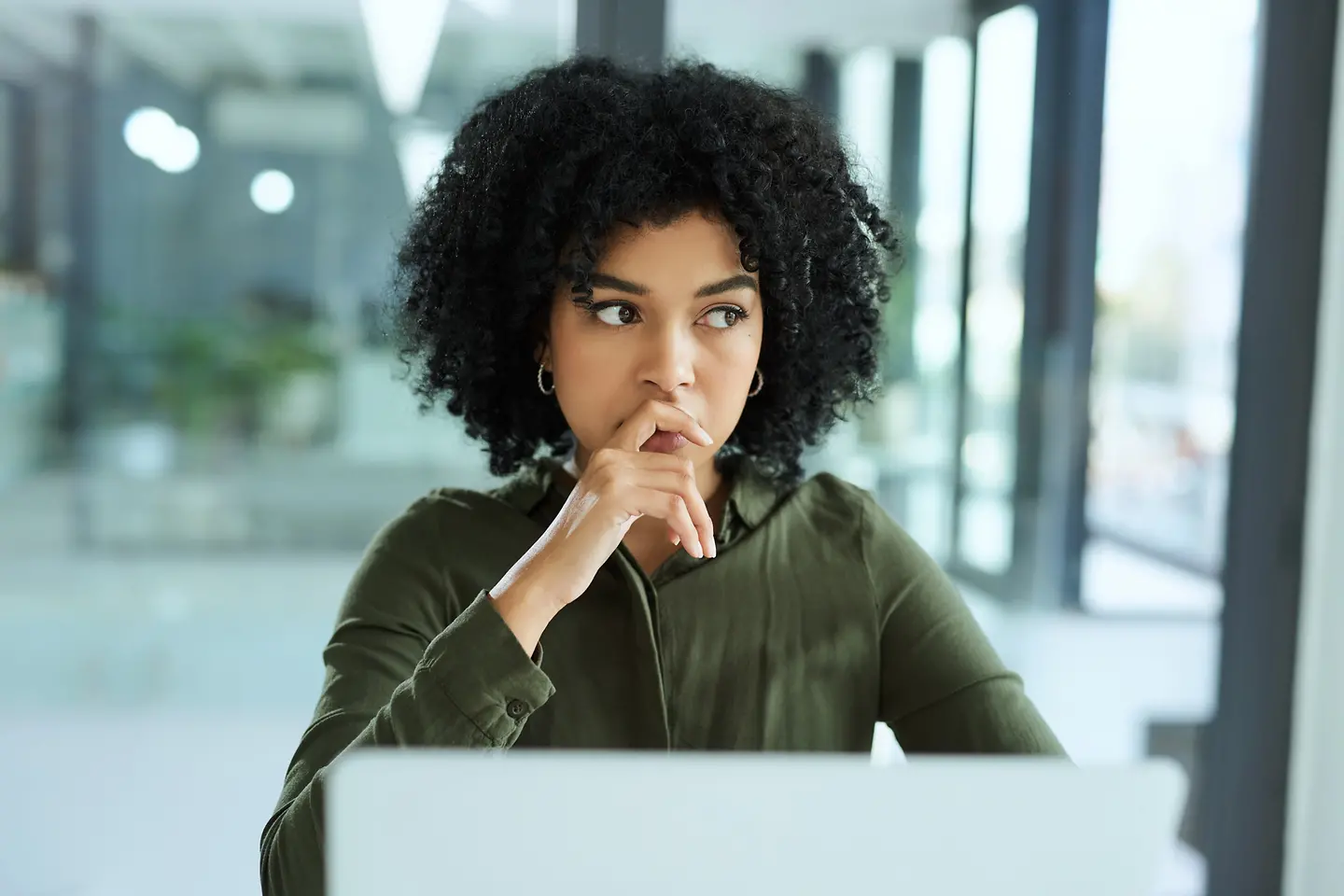 Junge Frau an ihrem Laptop in einem modernen Büro