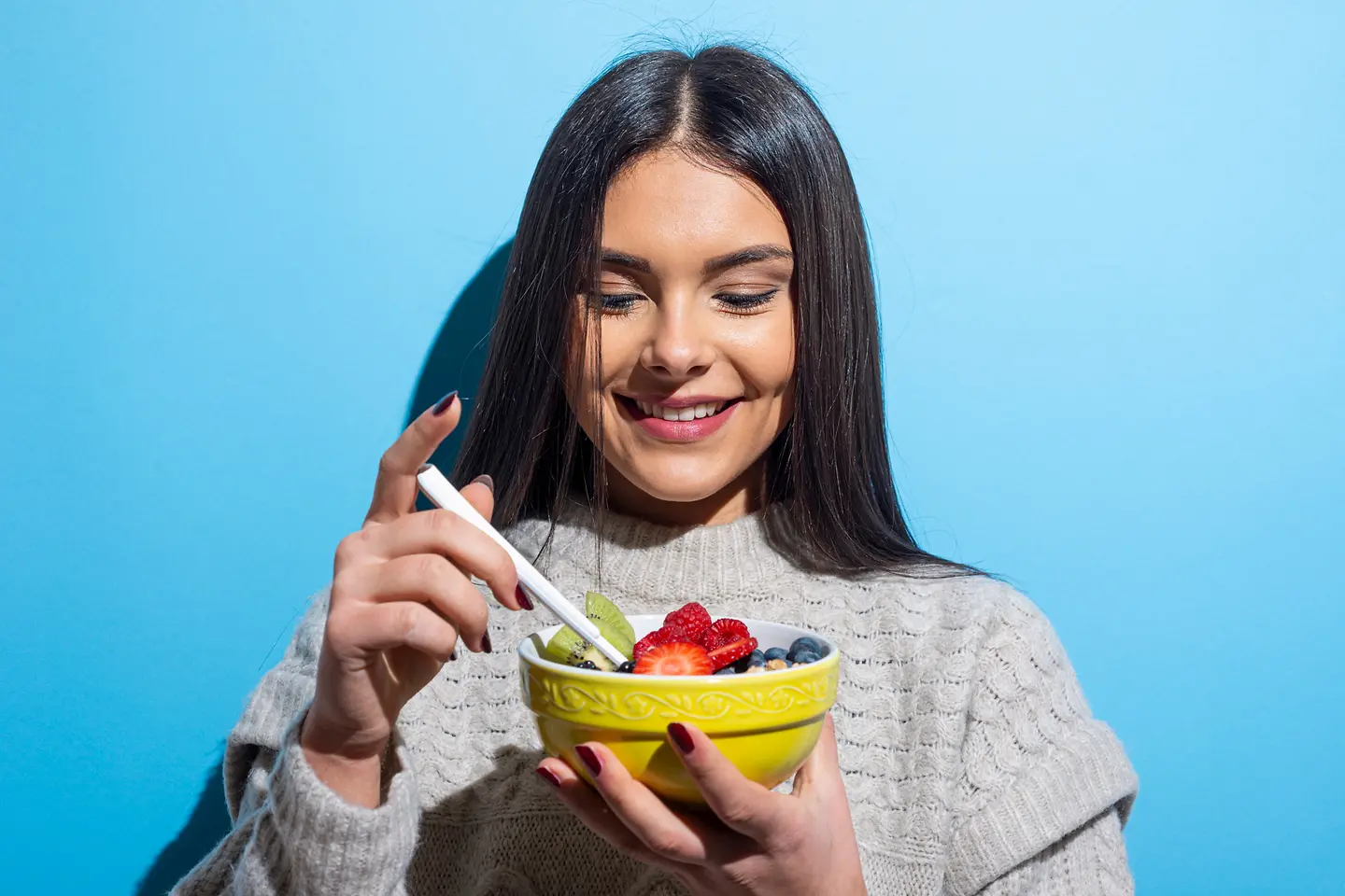 Junge Frau isst ein Müsli mit Obst