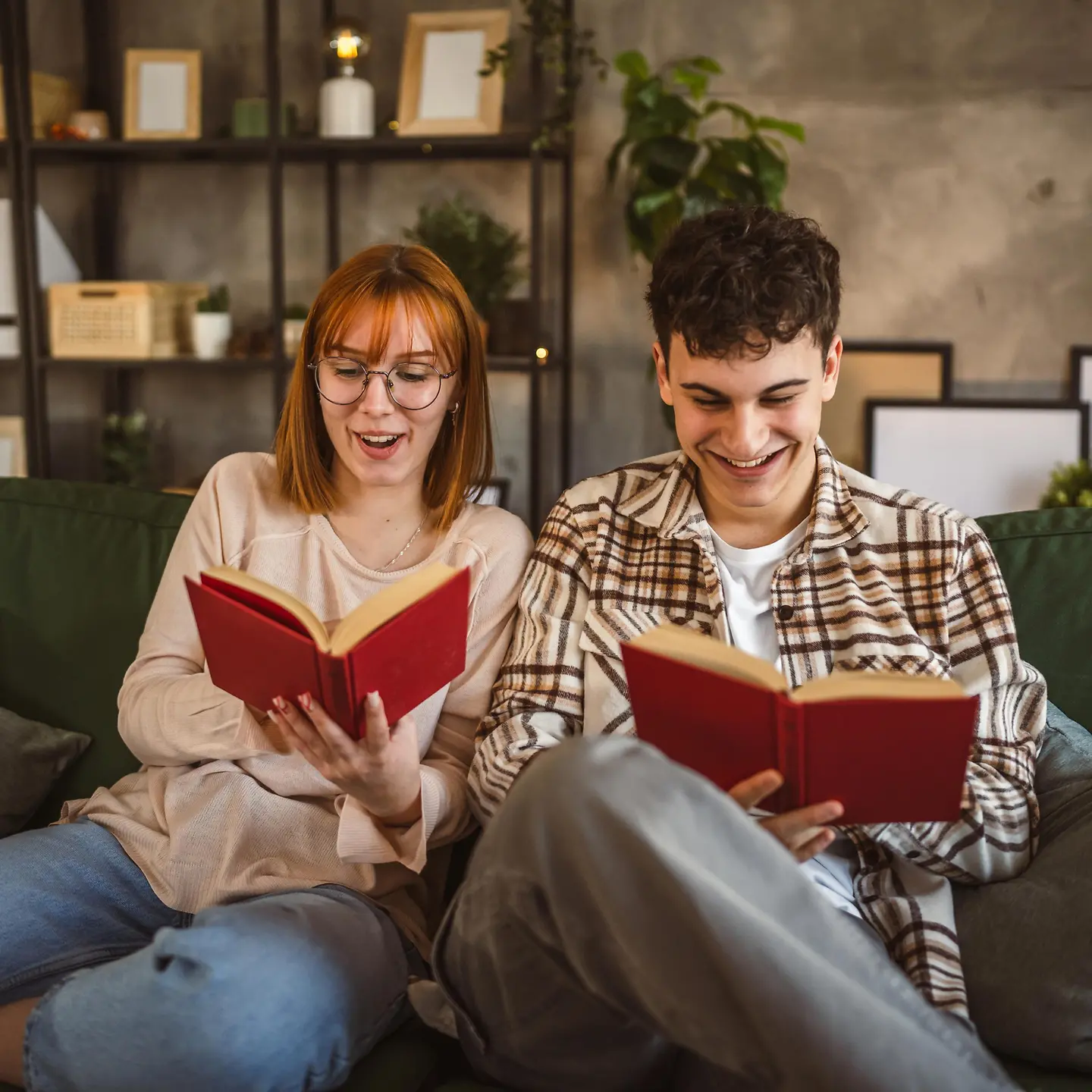 Asexualität: Ein junges Paar sitzt daheim auf einem Sofa und liest gemeinsam