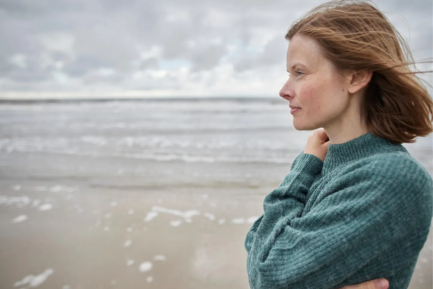 Nachdenkliche Frau blickt aufs Meer