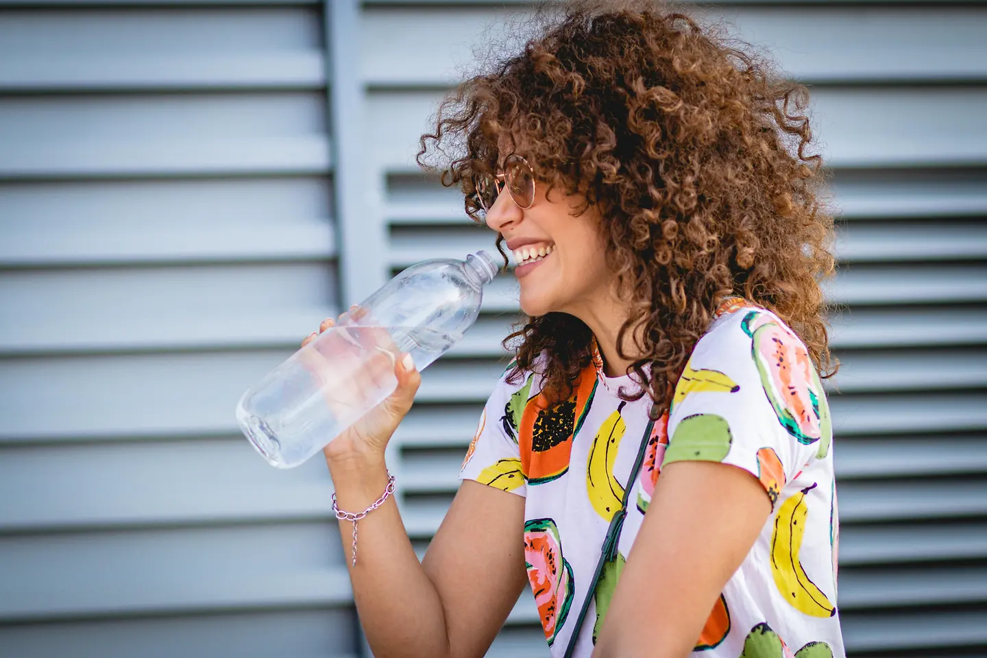 Mikroplastik im Körper: Eine junge Frau hält eine offene Flasche Wasser in der Hand