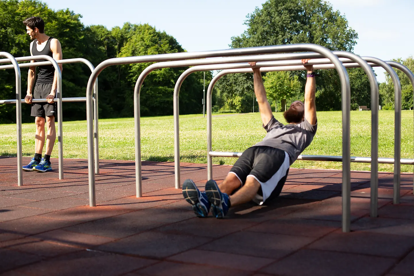Mann führt im Park Pull-ups an einer Stange durch