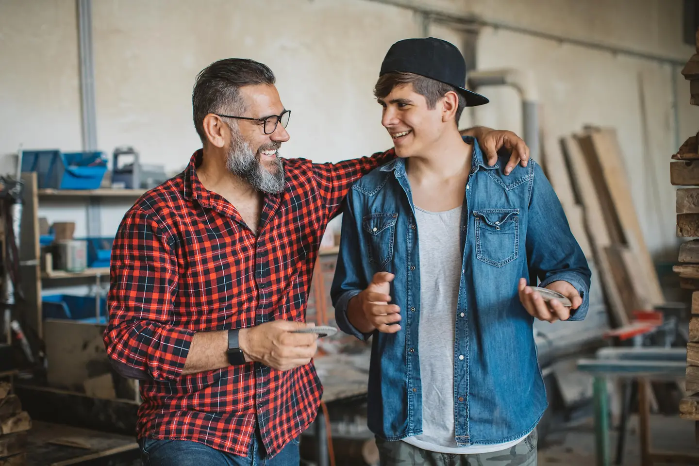 Vater und Sohn stehen in einer Werkstatt