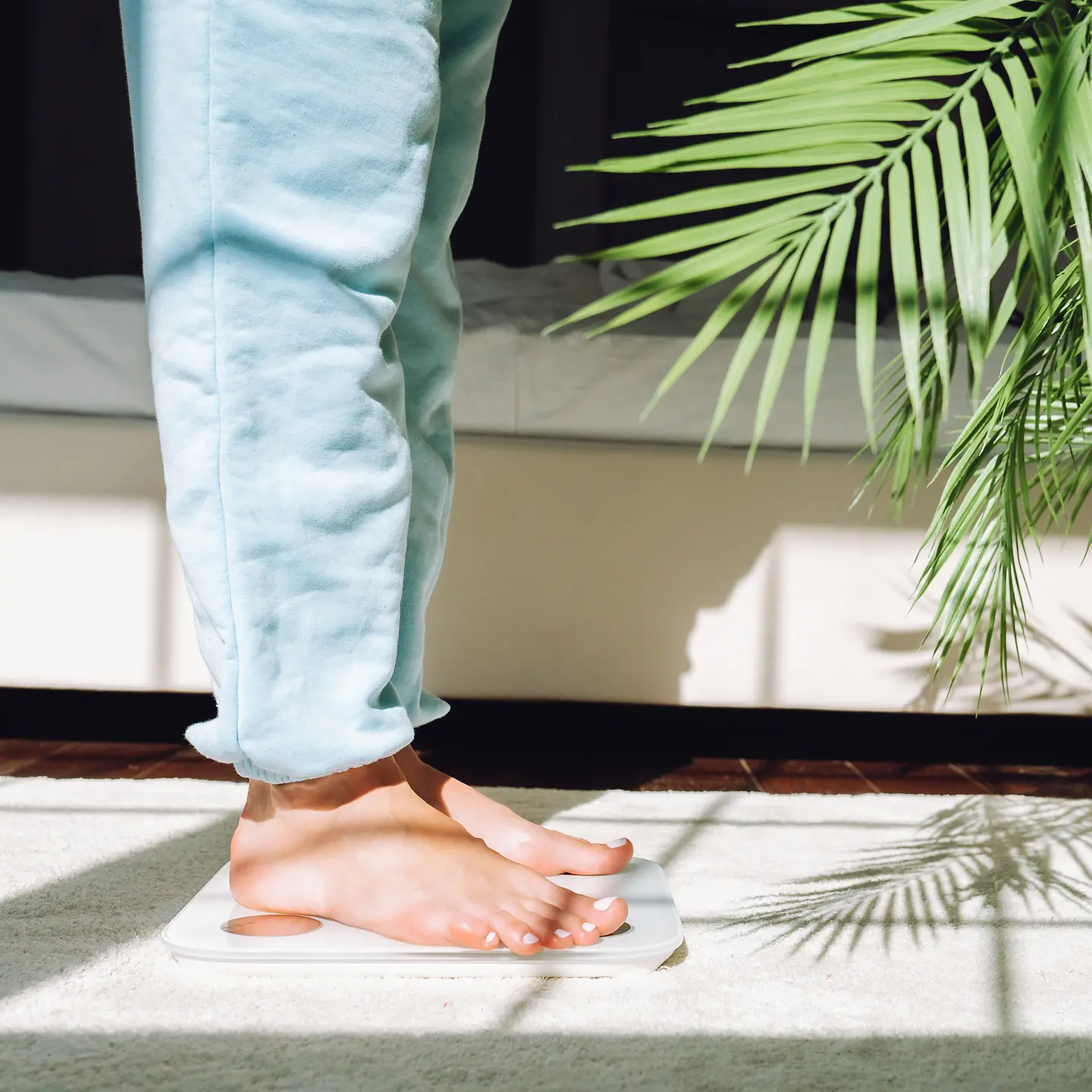 Abnehmspritze: Eine Frau in Jeans steht auf einer Waage